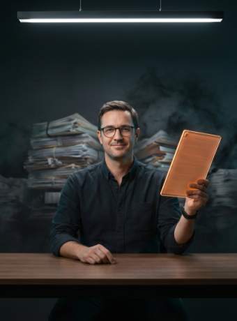 A small business owner holds a glowing neon orange document as heavy AI compliance paperwork dissolves away in a dramatic tech-noir setting