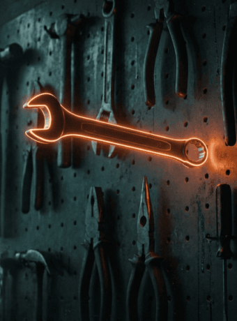 Glowing orange wrench on a tool wall in a workshop setting.