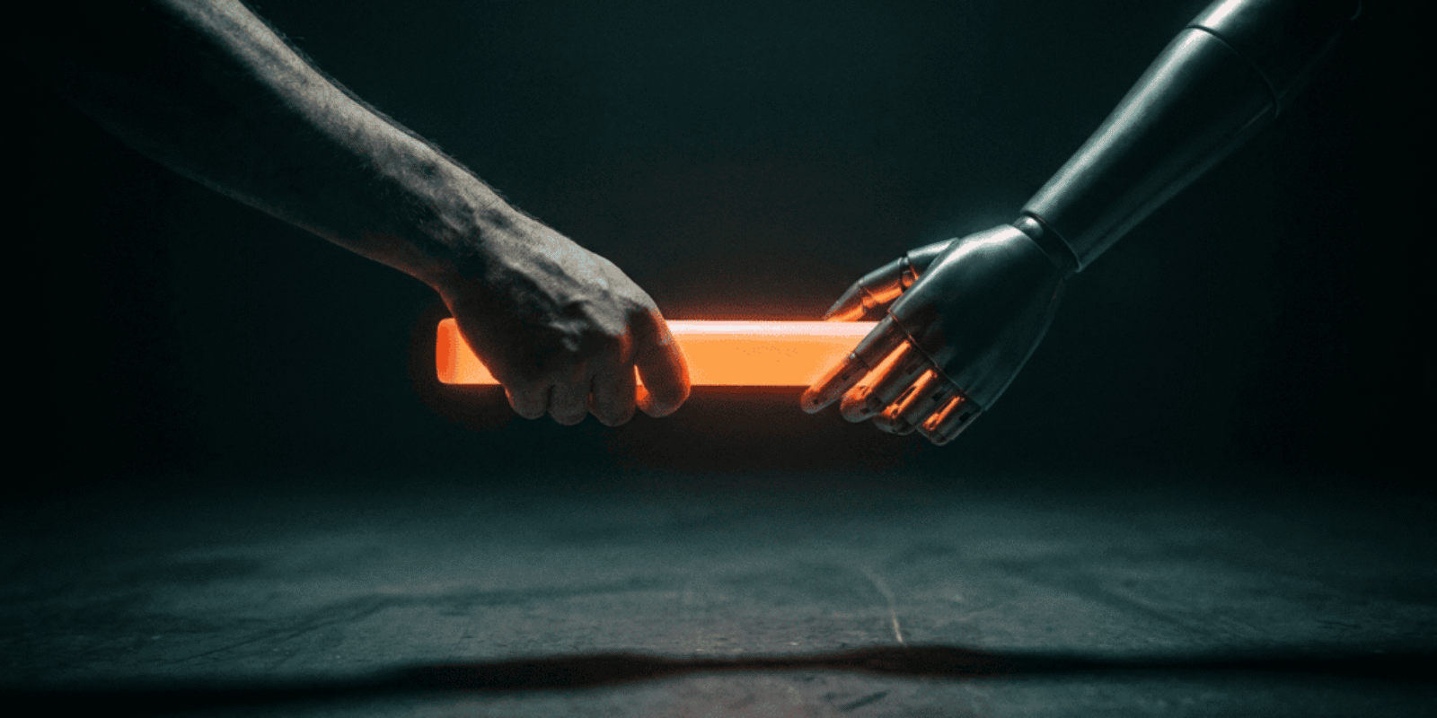 Human hand and robotic hand holding a glowing orange light stick.