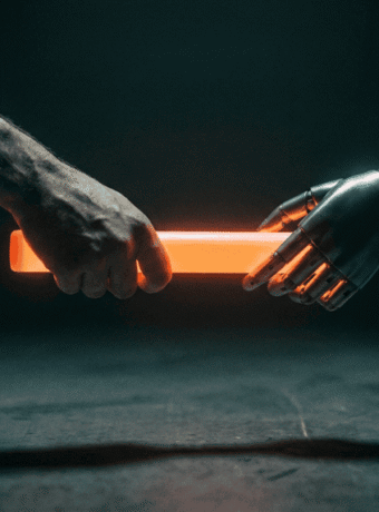 Human hand and robotic hand holding a glowing orange light stick.