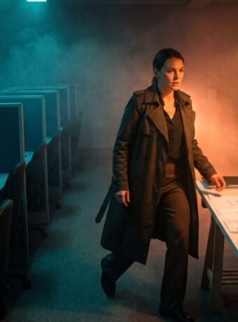 Woman in a dark office with AI and tech equipment, modern workspace.