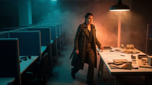 Woman in a dark office with AI and tech equipment, modern workspace.