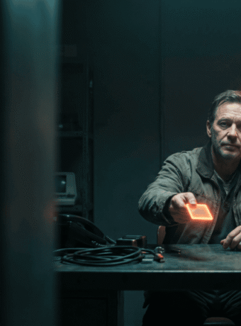 Man using advanced AI device with holographic AI figure in background.