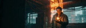 A tradesperson holds a small steady orange light while a towering orange holographic growth column rises behind them in a dark workshop