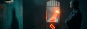 Man observing a glowing orange conveyor belt in a dark industrial setting.