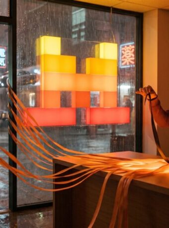 An office manager holds back one dark ribbon of light while the rest of the day's work streams out the door under a Mistral symbol sign